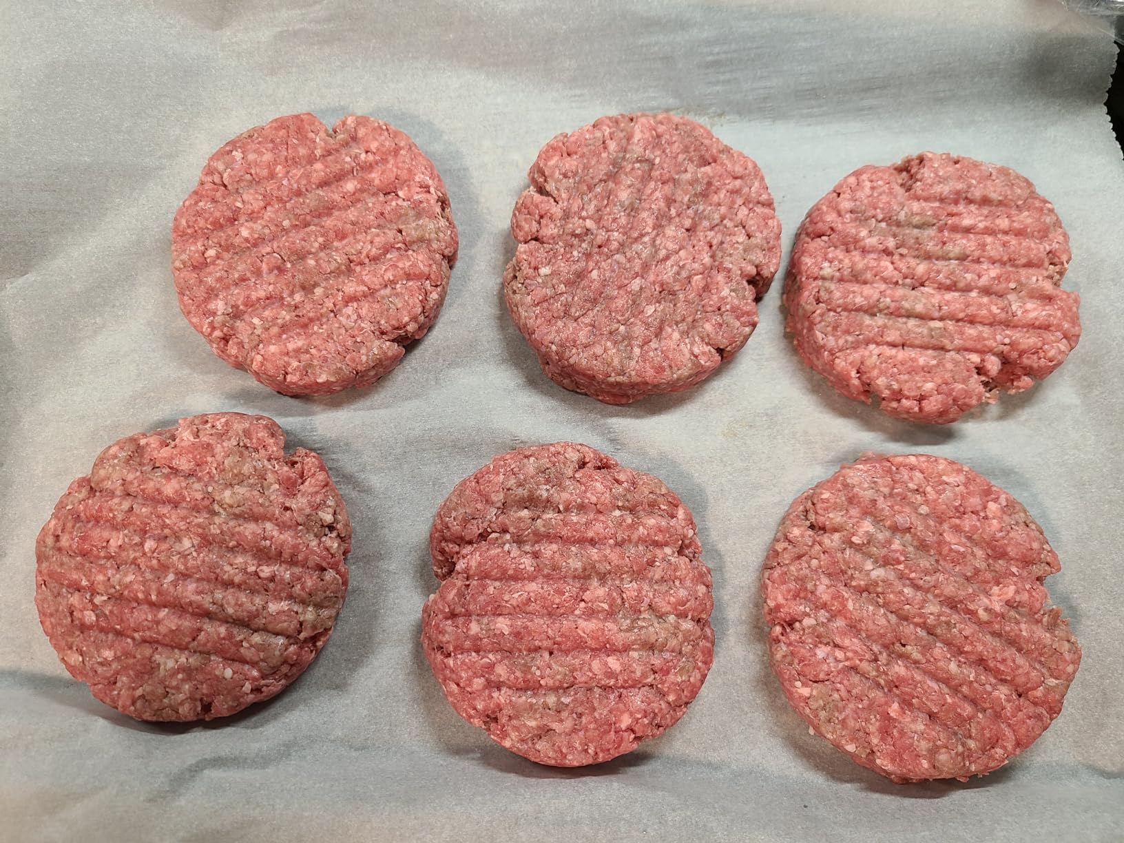 Six homemade burger patties prepared in a batch